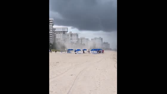 Dust devil forms along beach as waves crash in Florida, USA