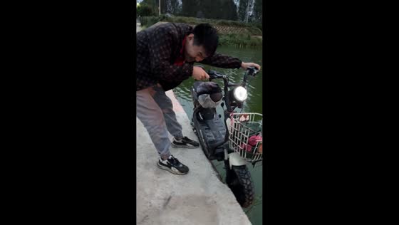 Man struggles as e-bike barely holds its ground near water in Shandong, China