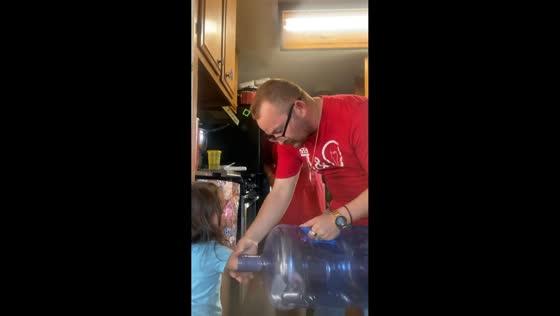 Parents help little girl after arm gets stuck in water gallon in Fontana, California, USA