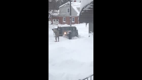 National Guard tries to free vehicle stuck in deep snow in Erie, Pennsylvania, USA