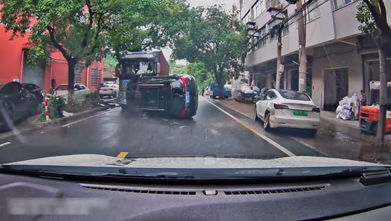 Black SUV flips over after crashing into parked vehicle on urban road in Zhejiang, China