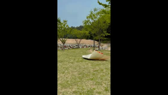 Wind folds picnic mat over woman during outdoor outing in Beijing, China
