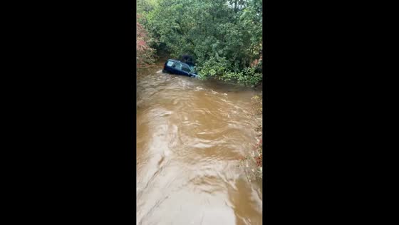Vehicle floats on flooded road in Bradford, UK