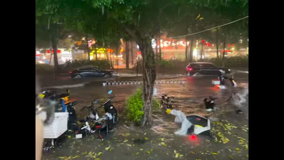 Vehicles drive through flooded street after three hours of heavy rain in Guangdong, China