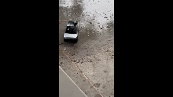 Remote-controlled Tesla Cybertruck delivers a bottle of beer in the rain in Odem, Texas, USA