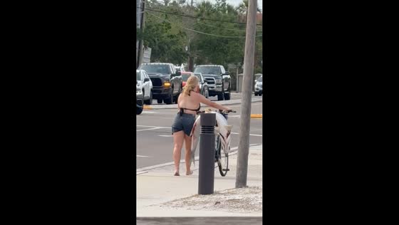 Woman pushes bike with giant fish on seat in Siesta Key, Florida