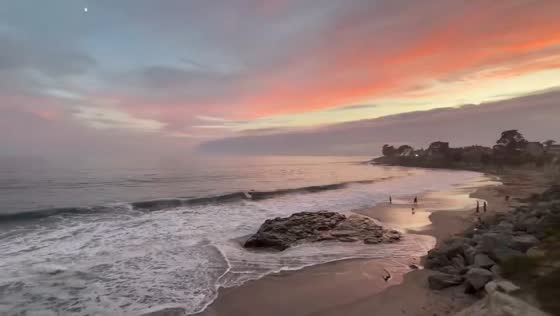 Sunset over calm ocean with rocky shore in Santa Cruz, USA