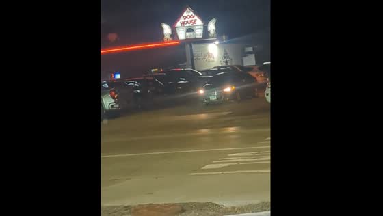Person reverses from parking lot near police car in Dubuque, Iowa