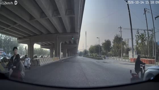 Car collides with an e-bike rider crossing the road beneath a flyover in Beijing, China
