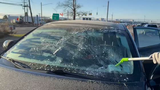 Woman quickly scrapes ice off windshield in New York, USA