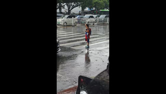 Driver gives umbrella to child caught in rain in Guangxi, China