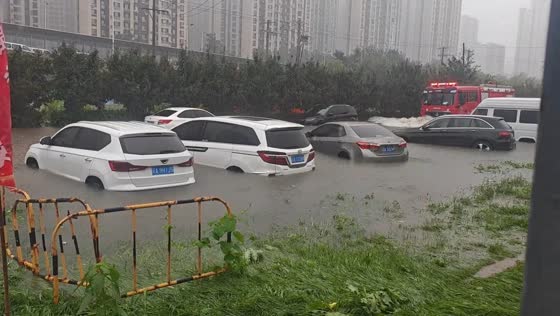 Fire truck creates waves on flooded road in Liaoning, China