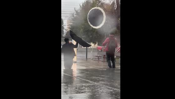 Wind blows away umbrella during rain in Talca, Chile