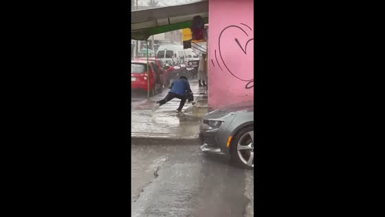 Man trips on hidden step after crossing street in rain in Ecatepec de Morelos, Mexico