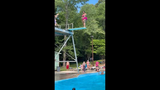 Woman makes confident dive off pool board in Hickory, North Carolina, USA