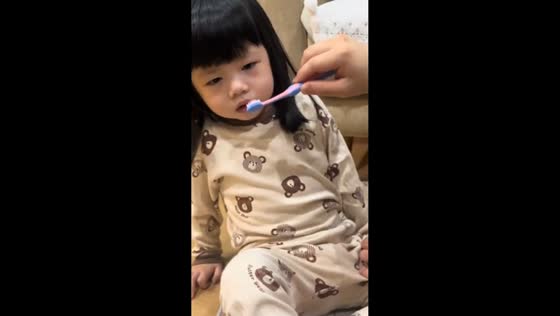 Daughter lets dog brush her teeth in Batam, Indonesia
