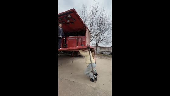 Woman struggles while helping set up mobile stage truck in Henan, China