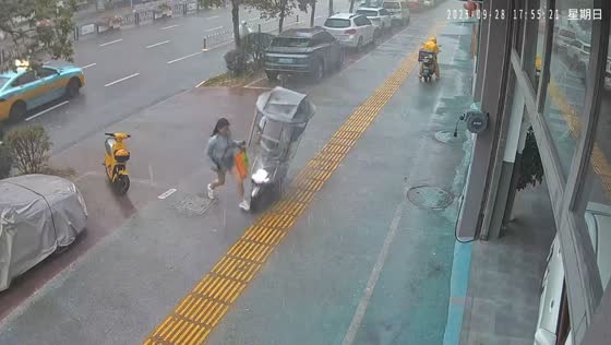 Electric motorcycle hits woman during heavy rain in Guangxi, China