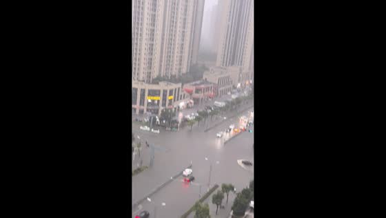 Lightning startles resident watching flooded street in Jiangsu, China