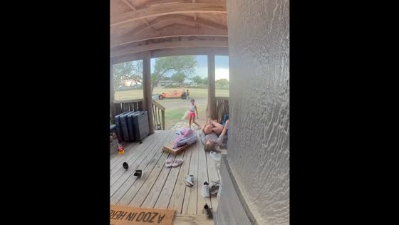 Child falls and laughs heartily on porch in Amarillo, Texas