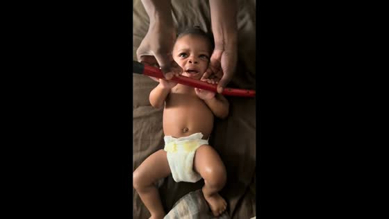 Baby pretends to lift weight with uncle in Gibsonton, Florida