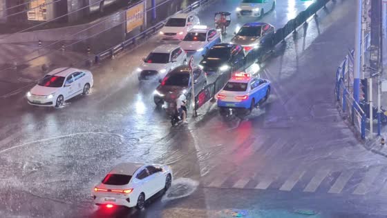 E-bike riders narrowly avoid crash during heavy rain in Guizhou, China