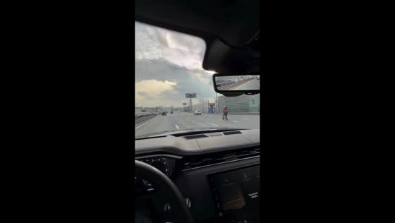 Scooter rider overtakes BMW at high speed on highway in Moscow, Russia
