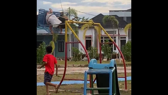 Children swing high on playground in Banjarmasin
