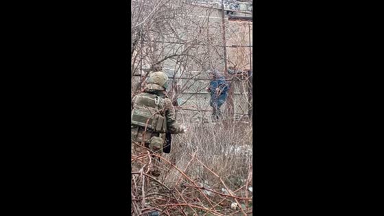Russian soldiers hand over food to elderly woman in Velyka Novosilka, Ukraine
