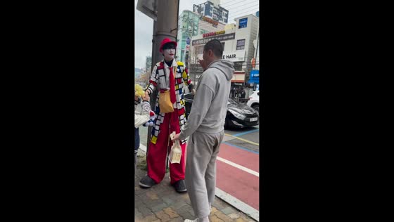 Tall man matches height with costumed performer in Busan, South Korea