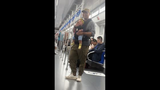 Father playfully taps crying baby’s mouth on train in Beijing, China
