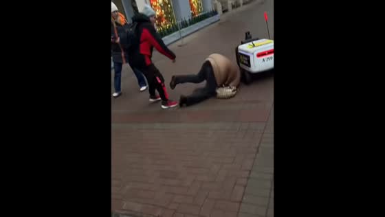 Woman trips over autonomous delivery robot on Stary Arbat Street, Moscow, Russia