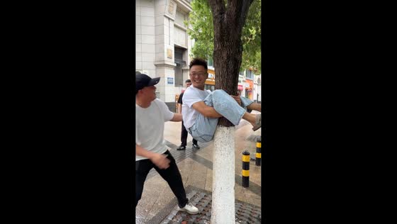 Man ends up stuck hugging tree after crab pose prank in Zhejiang, China