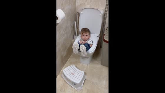Toddler sitting in toilet bowl in Belgrade, Serbia