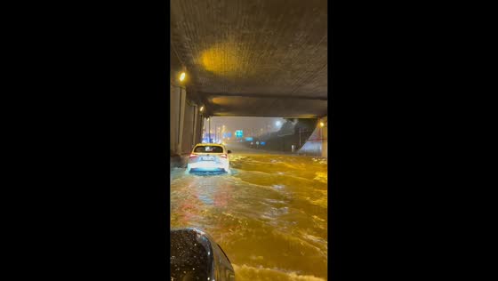 Cars wade through deep floodwater in tunnel in Barcelona, Spain