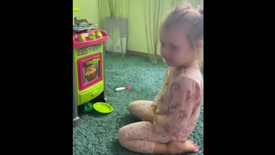 Young girl refuses toy cooking in playful kitchen moment in Dnipro, Ukraine