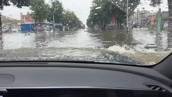 Car drives through deeply flooded road in Zhejiang, China