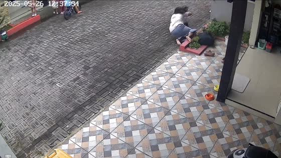 Woman loses balance and falls while taking off slippers in Surakarta, Indonesia