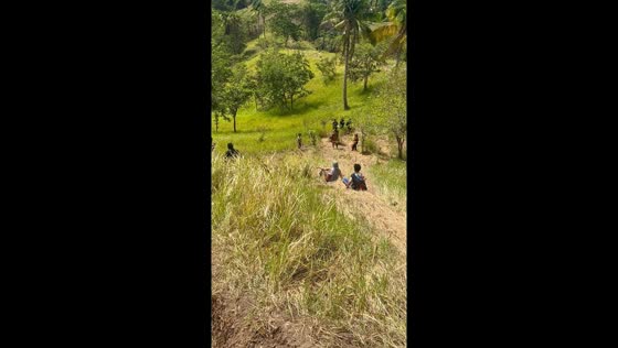 Hiker slides down grassy slope and is caught at the bottom in Samal, Davao, Philippines