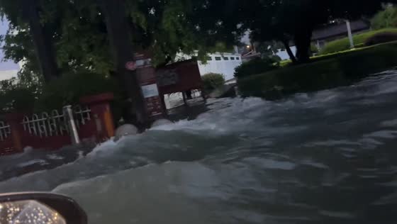 Car drives through flooded neighborhood in Guangdong, China