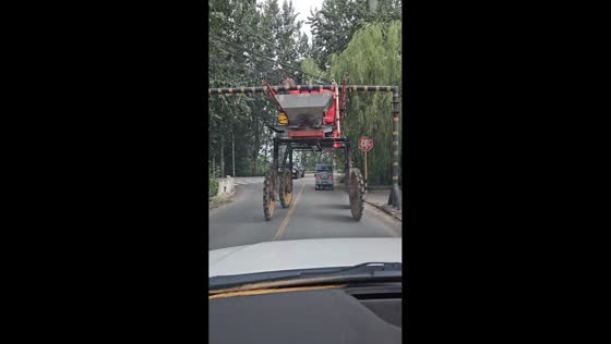 Agricultural sprayer barely passes under height clearance bar in Beijing, China