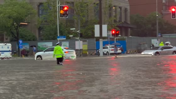 Traffic officer wades through floodwaters in Shanghai, China