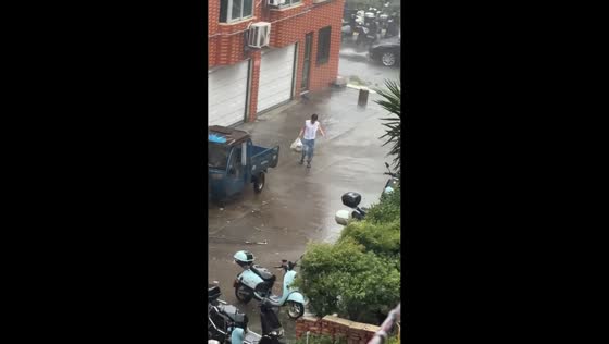 Woman loses a slipper during a heavy storm in Zhejiang, China