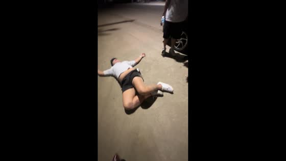 Drunk friends struggle to move along roadside in Iligan, Philippines
