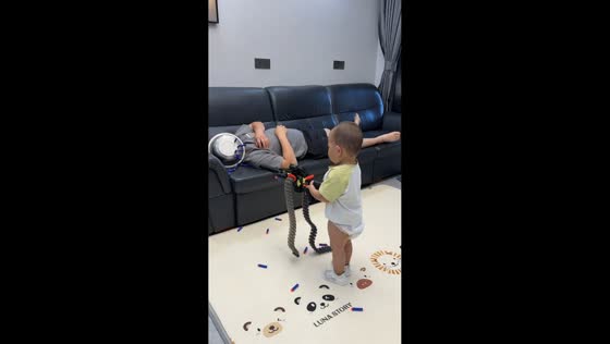 Toddler plays with toy gun while dad sleeps in Anhui, China