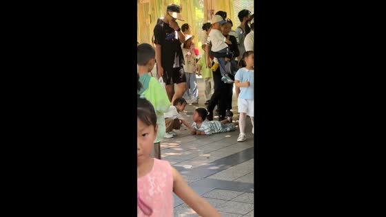 Little girl gently helps shy boy off the street in Henan, China