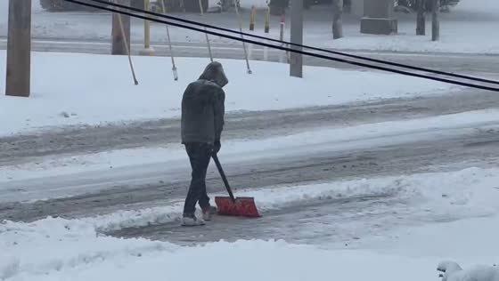 Man clears pathway through heavy snowfall in Highland, Indiana, USA
