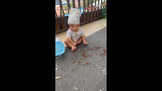 Cat gives angry look after baby makes a mess in Balikpapan, Indonesia
