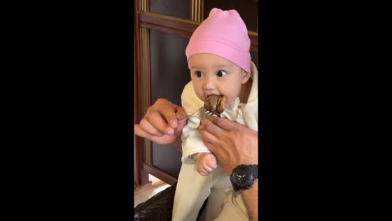Hungry baby eagerly enjoys meat in Nalchik, Russia