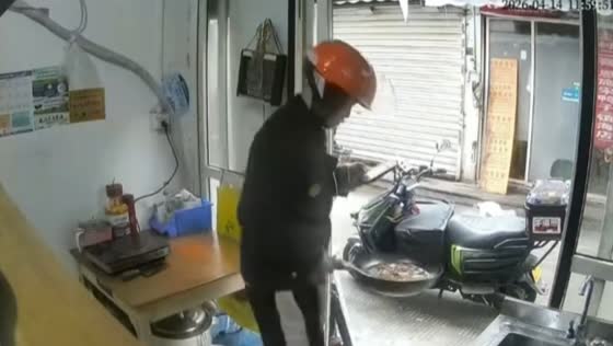 Delivery rider mistakenly grabs food from pan in Zhejiang, China